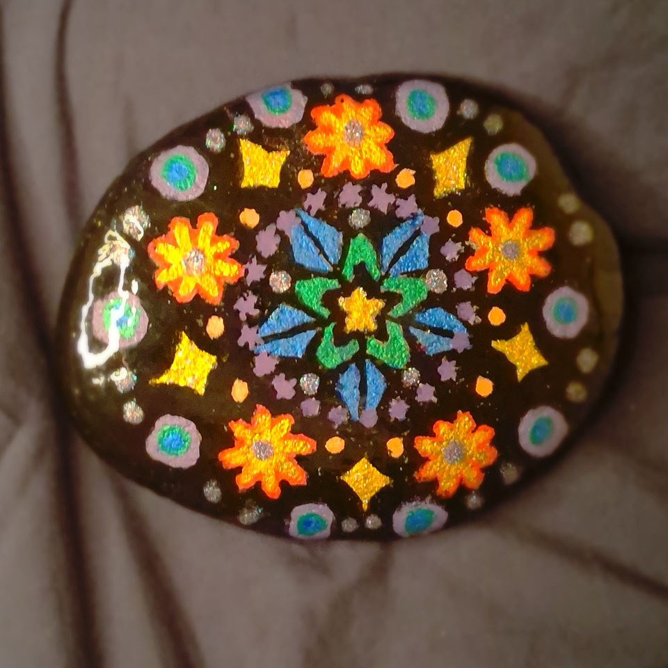 Hex — a hand-painted star-and-blossom mandala on a canyon flat stone